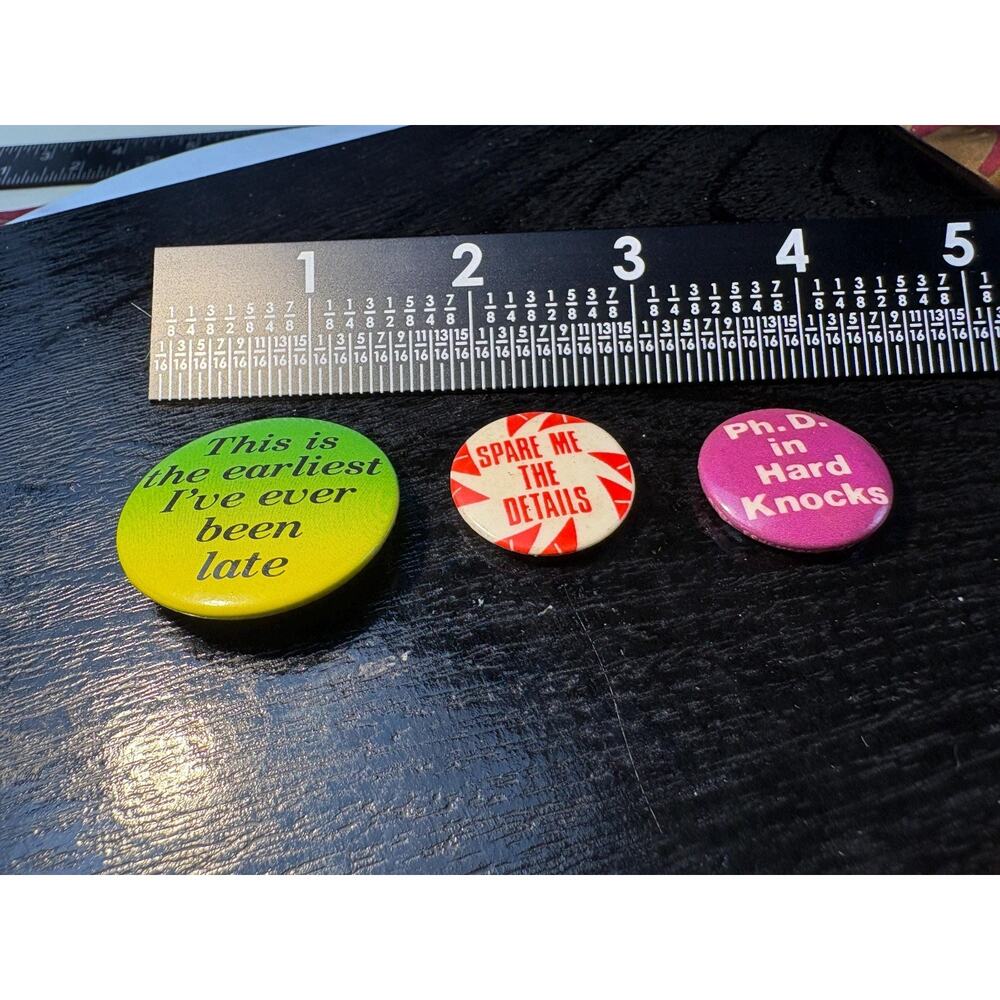 Three vintage pin back buttons with funny phrases.